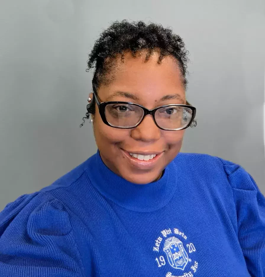 Rahgna J. Lewis in a blue sweater.